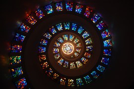 eine Spirale aus verschiedenenfarbigen Glassteinen, durch die Licht scheint